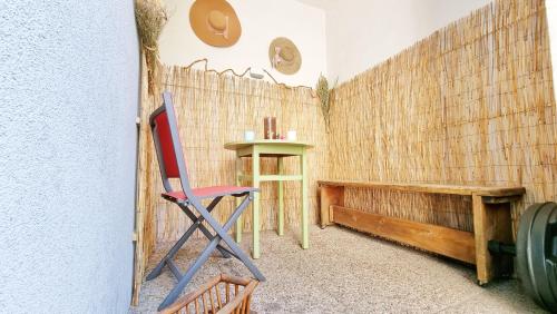 Cette chambre comprend une chaise rouge et un banc en bois. dans l'établissement Le Stan - Centre - Parking - Extérieur - Fibre - Relax BNB, à Colmar