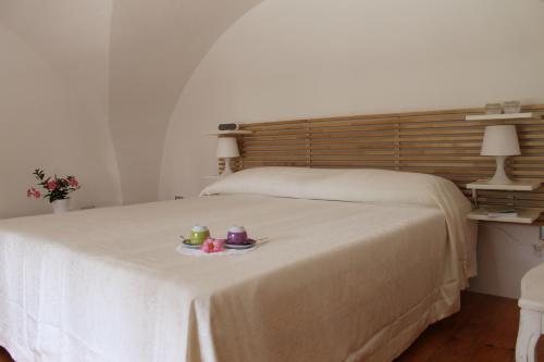 Una cama con dos tazas y un plato. en Il Cortile Segreto, en Lecce