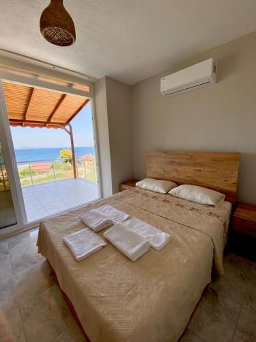 a bedroom with a large bed with towels on it at Limonlu Bahçe Butik Otel in Karaburun