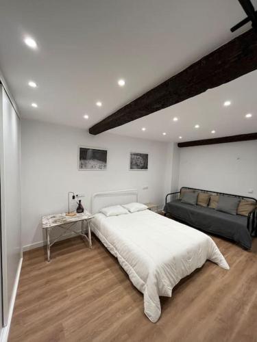 um quarto com uma cama grande e um sofá em Chapitela Suite em Pamplona