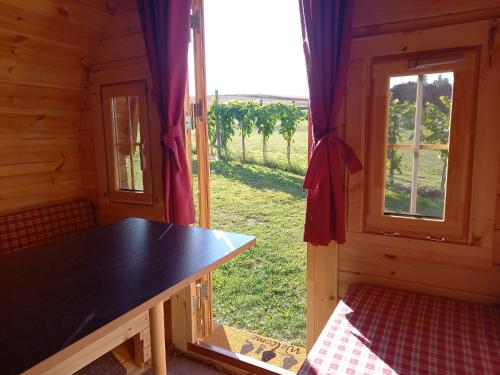 Habitación con mesa y ventana con vistas. en Andrella Auszeithof - Schlaferlebnis im Holzfass, en Friedersbach