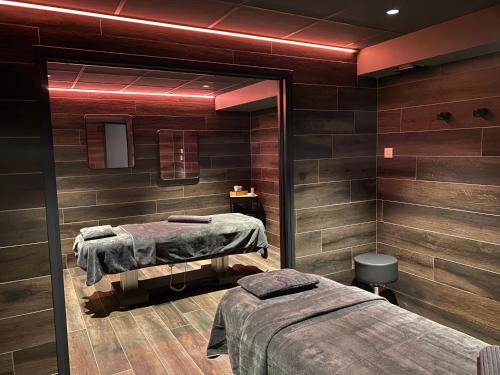 a room with two beds and a mirror at Hôtel 16 | 150 Montagne & Spa Nuxe in Vars