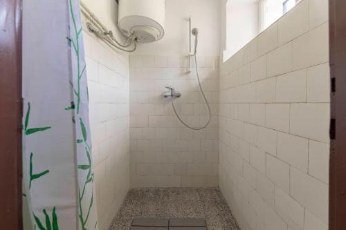 a bathroom with a shower with white tiles at Šentjane bay view house in Portorož