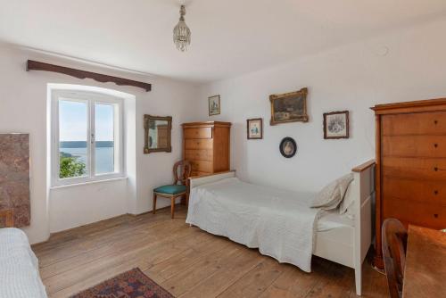a bedroom with a bed and a window at Šentjane bay view house in Portorož