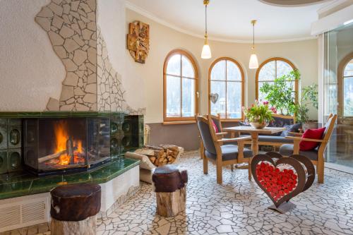 a living room with a fireplace and a table at Mountainclub Hotel Ronach in Königsleiten
