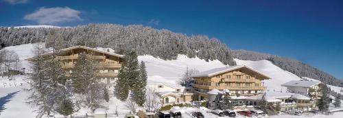 un gran edificio en una montaña cubierta de nieve en Mountainclub Hotel Ronach en Königsleiten