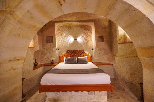 a bedroom with a bed in a stone room at Canyon Cave Hotel in Urgup