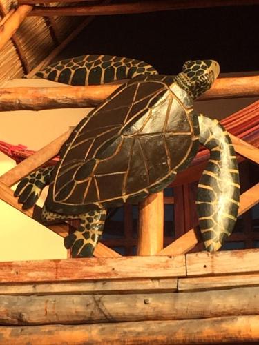a statue of a turtle on a wooden beam at Vilancool Beach Resort in Vilanculos