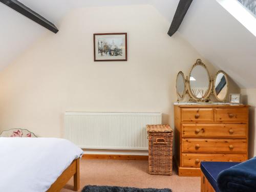 - une chambre avec un lit et une commode avec des miroirs dans l'établissement Northwood Barn, à Okehampton