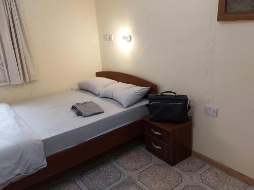 Un dormitorio con una cama con una bolsa. en Charming 2-Bed Cottage in Benin City, en Benin City