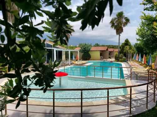 uma piscina num resort com cadeiras e guarda-sóis em Resort Te Zagolli em Orikum