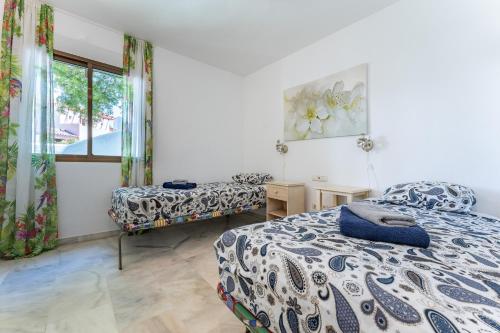 sypialnia z dwoma łóżkami i oknem w obiekcie Golden Beach Elviria w Marbelli