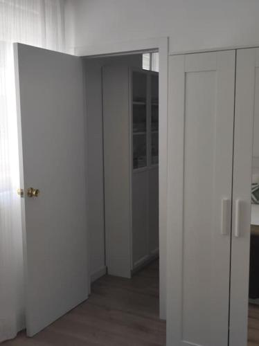 an empty room with white walls and an open door at Casa Dina II. in Carballino