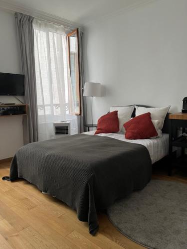- une chambre avec un grand lit et 2 oreillers rouges dans l'établissement MaisonZen, à Paris