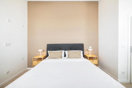 a bedroom with a large white bed with two lamps at Lisbon Oriente Suites by Olala Homes in Lisbon