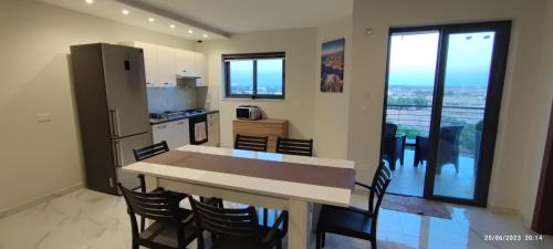 a kitchen and dining room with a table and chairs at Skyline Court Holiday Apartments in Hal Ghaxiak