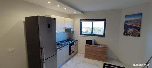 a kitchen with a refrigerator and a stove and a window at Skyline Court Holiday Apartments in Hal Ghaxiak