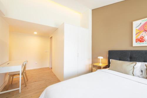 um quarto com uma cama branca e uma secretária em Lisbon Oriente Suites by Olala Homes em Lisboa