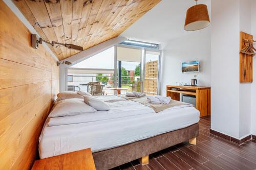 a bedroom with a large bed and a desk at KOMPAS in Jastrzębia Góra