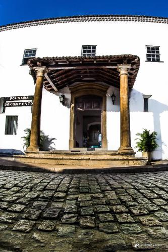 an entrance to a white building with a stone courtyard at Pousada Convento do Carmo in Cachoeira