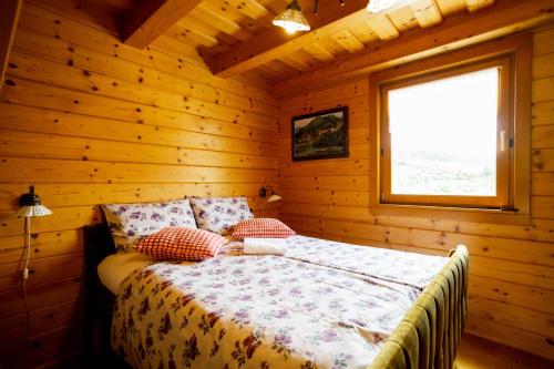 um quarto com uma cama num chalé de madeira em Apartma Smithy (Kovačnica) em Laško
