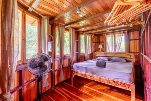 a bedroom in a tree house with a bed and a fan at Paradiselodge Jungleguesthouse in Platanillo