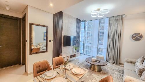 a living room with a table and a couch at STAY BY LATINEM Luxury 1BR Holiday Home CV B905 near Burj Khalifa in Dubai