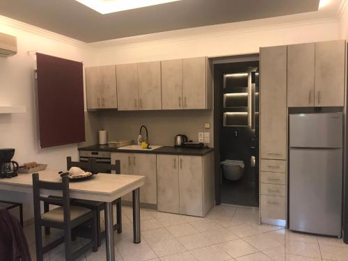 a kitchen with white cabinets and a table and a refrigerator at Edem in Vatera
