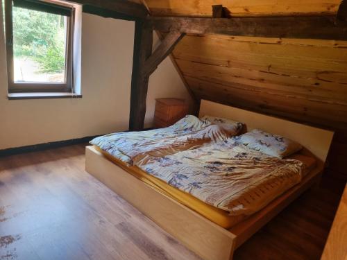 a bedroom with a bed in a room with a window at Dom wakacyjny nad jeziorem Jodłów in Nowa Sól