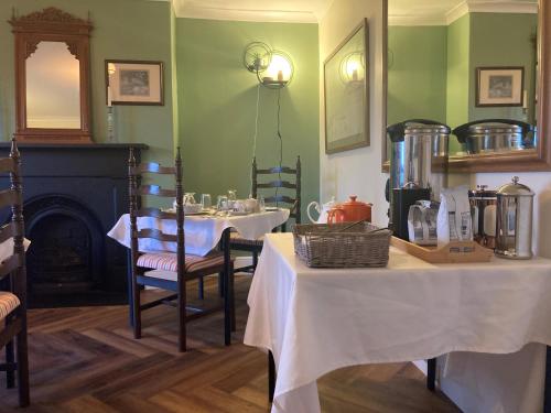 a dining room with two tables and a fireplace at Penyvoel Hall in Llanymynech