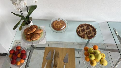 una mesa de cristal con varias frutas y pasteles. en Hotel Rio Sanremo, en San Remo