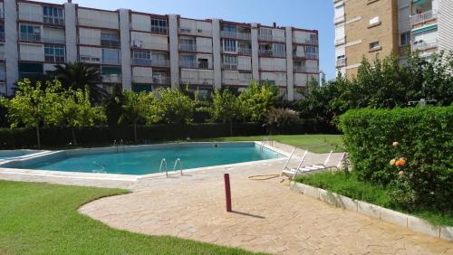 a swimming pool in front of a building at EL PISET in La Pineda