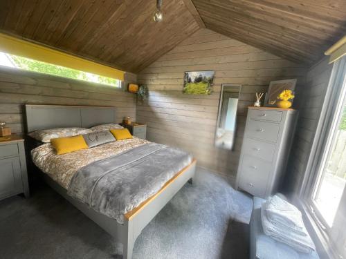 a bedroom with a bed in a wooden room at Daisy Cabin in Kincardine OʼNeil