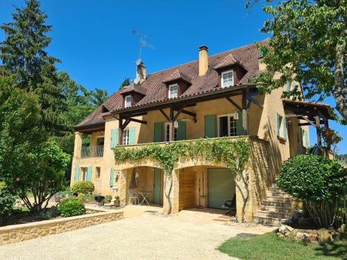 a large house with a garage in front of it at Le Malpas Kingfisher in Belvès