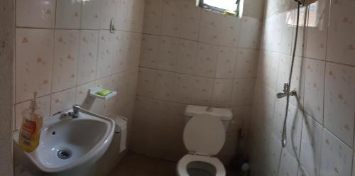 a small bathroom with a toilet and a sink at Randa's House I Homestay in Ruhengeri