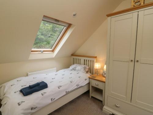 a small bedroom with a bed and a window at Gelli Barn in Llandeilo