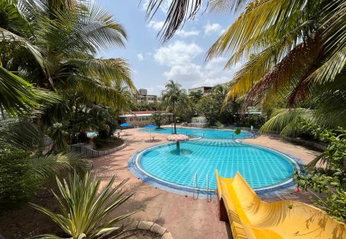 una gran piscina rodeada de palmeras. en Hotel Sai leela - Shirdi en Shirdi