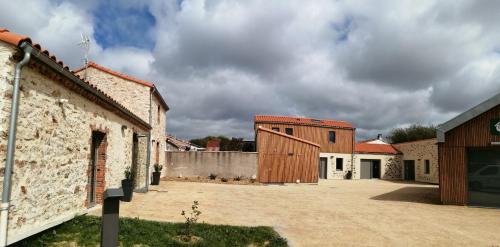a barn conversion with a building in the background at LA BORDERIE - MAISON DES RANDONNEES - Gîte étape - gîte de groupe in Vairé