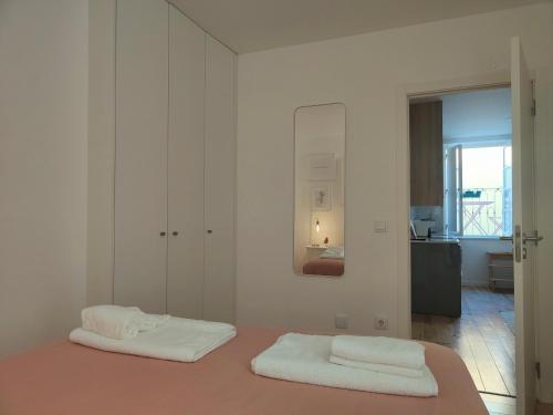um quarto branco com duas toalhas brancas numa cama em Rose Essence Aparment - Exceptional balcony em Coimbra