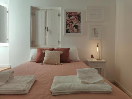 um quarto com uma cama com duas toalhas em Rose Essence Aparment - Exceptional balcony em Coimbra