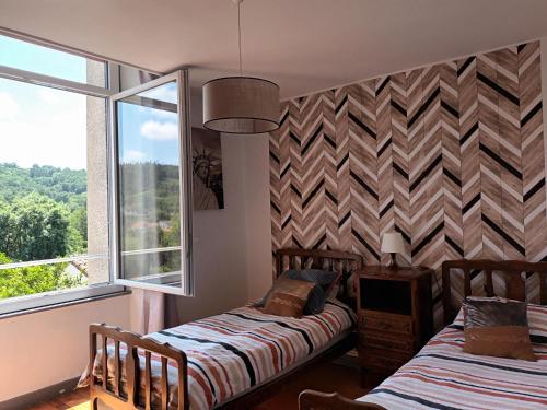 a bedroom with two beds and a window at Appartement chaleureux de 82M2 proche de Vulcania in Pontaumur