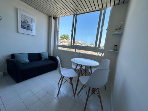 a living room with a couch and a table and chairs at Studio Antibes Port Vauban. in Antibes