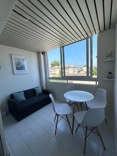 un salon avec une table, des chaises et un canapé dans l'établissement Studio Antibes Port Vauban., à Antibes