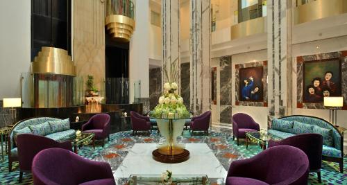 a lobby with purple chairs and a christmas tree in the middle at Hotel Marine Plaza in Mumbai