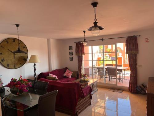 ein Wohnzimmer mit einem Sofa und einer Uhr an der Wand in der Unterkunft Apartment Duquesa Regent in Manilva