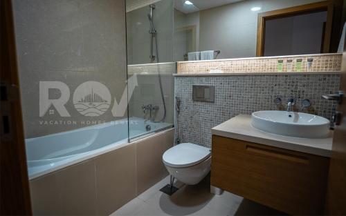 een badkamer met een wastafel, een toilet en een bad bij Studio with Boulevard View in Dubai