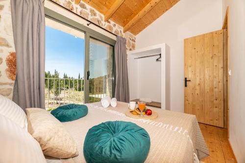 a room with a bed with pillows and a large window at Misovounous Natural Park Villa by "elite" in Agios Leon