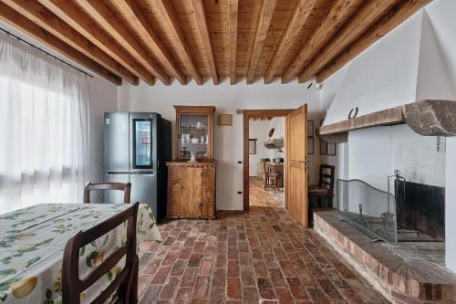 a room with a kitchen with a refrigerator and a table at Country house Viaro_150sqm in Vanzo