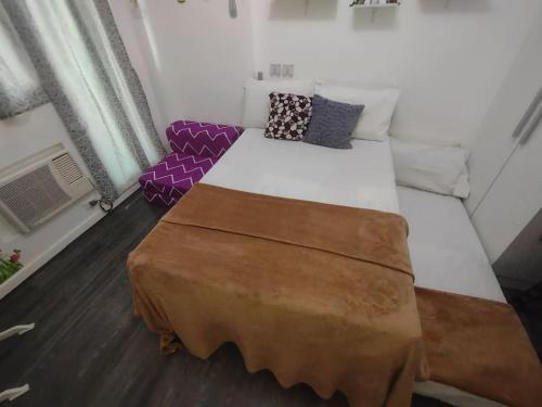 een groot bed in een kamer met een bank bij Pampanga Staycation Condo Unit In San Fernando in San Fernando