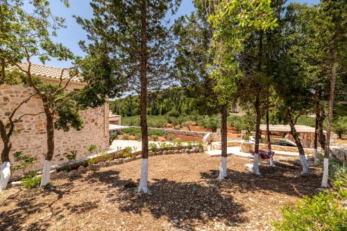 a group of trees in a yard next to a building at Misovounous Natural Park Villa by "elite" in Agios Leon